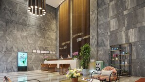 A modern lobby with a reception desk, seating area, and decorative plants. - Shenzhen Hongdu Hotel (Shenzhen)