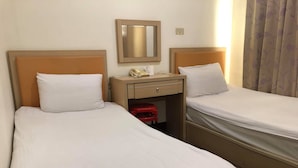 A hotel room with two beds, a wooden headboard, a bedside table with a telephone, and a mirror on the wall. - Huasin Hotel (Jincheng)