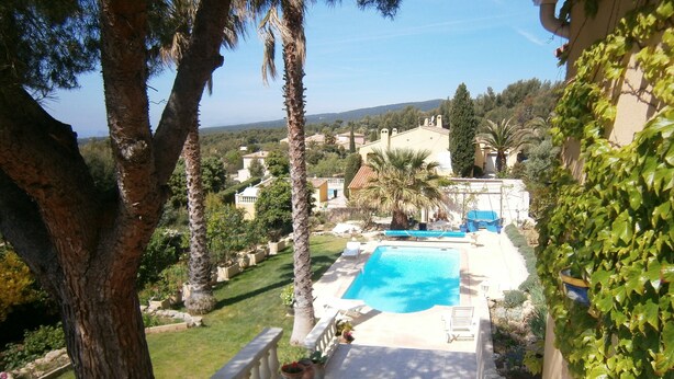 A pool area with a clear view of the surrounding landscape, including trees and buildings. - DUPLEX APARTMENT, SEA VIEW (La Cadière-d'Azur)