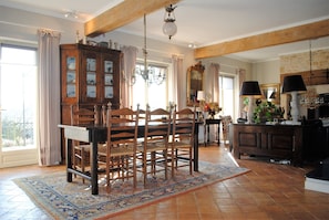 Enjoy meals in this elegant dining area with a traditional table and chairs, surrounded by a large cabinet and adorned with a chandelier.