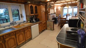 A rustic kitchen with wooden cabinets, a dishwasher, and a stone island. - Family House with Large Garden & Games Room near Bambois Lake (Mettet)