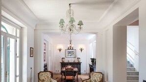 A spacious foyer with a chandelier, two armchairs, a dining table, and a staircase. - Villa in Paceco Near Marsala Beaches (Paceco)