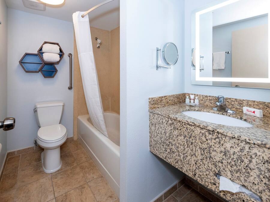 A bathroom with a toilet, shower, and sink.
