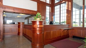 A kitchen with wooden cabinetry, a granite countertop, and a potted plant on the island. - HomeTowne Studios by Red Roof Wilmington - New Castle (New Castle)