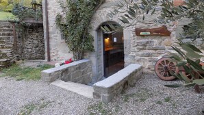 A stone building with a wooden door, a stone bench, and a sign indicating 'Alia Via dei Parchi'. - Comfortable Home in San Godenzo near Lake (San Godenzo)