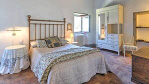 A bedroom with a wooden bed, a white dresser, a mirror, and a small table. - Comfortable Home in San Godenzo near Lake (San Godenzo)