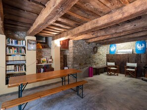 Cozy interior space with a long bench, bookshelf, and simple dining area.