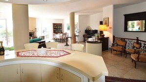 A spacious living area with a curved white counter, a dining table, and a piano. - Belvilla by OYO Villino Lucrezia (Meina)