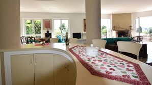 A spacious living area with a dining table, chairs, and a fireplace. - Belvilla by OYO Villino Lucrezia (Meina)
