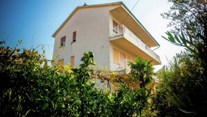 A two-story building with a balcony on the upper floor. - Charming Apartment on Croatian Islands (Malinska-Dubasnica)