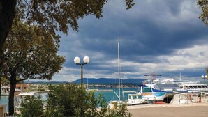 A marina with boats docked, a clear sky, and a mountainous backdrop. - Charming Apartment on Croatian Islands (Malinska-Dubasnica)
