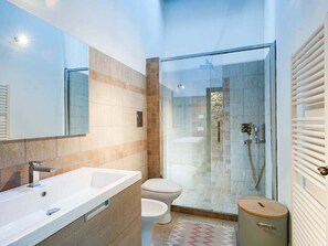 A modern bathroom with a large mirror, a white sink, a toilet, and a glass-enclosed shower area. - Belvilla by OYO Maranzano Marietta (Buseto Palizzolo)