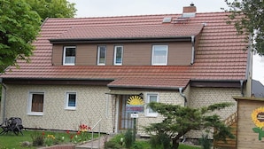 A two-story house with a red-tiled roof and a garden in front. - Wohnung mit Garten in Wieck a. Darss (Wieck auf dem Darss)