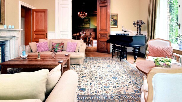 A spacious living room with a grand piano, a chandelier, and a large window with curtains. - Spacious Pet-friendly Castle in Stavelot (Stavelot)