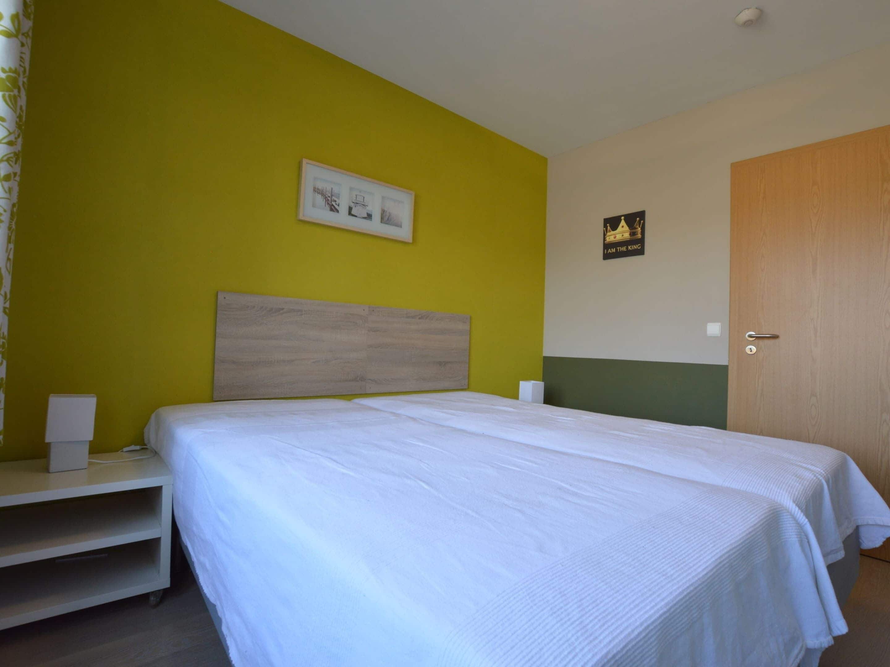 Ein Schlafzimmer mit einem Bett, Nachttischen und einer Tür.
