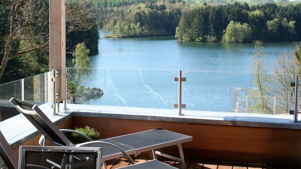A balcony with a view of a lake and forest. - Robertville Lakeview Escape (Waimes)