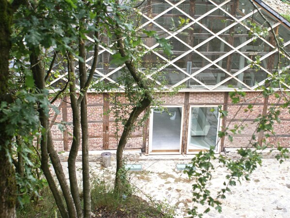 A building with a brick facade, large windows, and a stone ground.