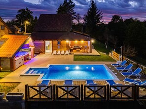 A swimming pool with lounge chairs, a hot tub, and a wooden deck. - Holiday Home in Ogulin With Pool & Rafting (Ogulin)