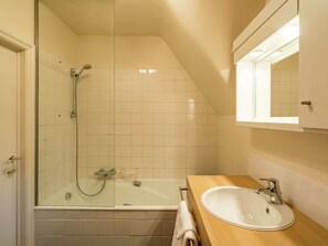 A bathroom with a glass-enclosed shower, a bathtub, and a sink with a mirror above it. - Oostduinkerke Forestside Villa (Koksijde)