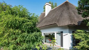 A house with a thatched roof, a visible chimney, and a window with the name 'Wieselsdorf'. - Oostduinkerke Forestside Villa (Koksijde)