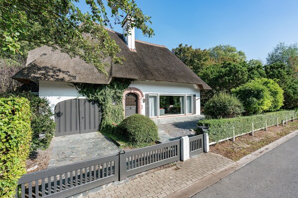 A house with a thatched roof, a white exterior, and a gated entrance. - Oostduinkerke Forestside Villa (Koksijde)