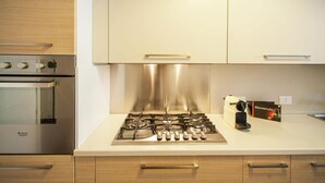 Una cucina moderna con elettrodomestici in acciaio inossidabile, mobili in legno e un design pulito e minimalista.