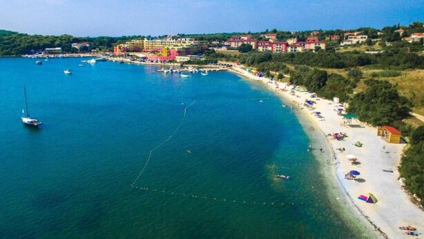An aerial view of a coastal area with a beach, boats, and buildings. - Comfortable Holiday Home Only 500m to the sea With Outdoor Kitchen, Wifi and Airco (Medulin)