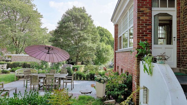 A patio with outdoor furniture and a large umbrella. - Stavelot Sauna & Garden Stay (Stavelot)