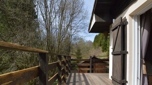 Eine Holzterrasse führt zu einem Gebäude mit einer großen Schiebetür.