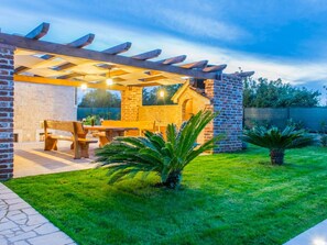 A patio with a pergola, outdoor seating, and a brick wall. - Lovely Holiday Home in Fazana With Swimming Pool (Fazana)