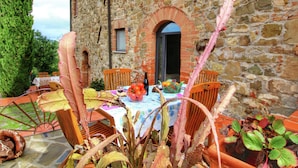 A stone building with a rustic outdoor seating area.