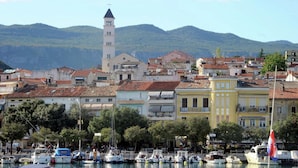 A coastal town with a prominent tower, colorful buildings, and a marina with boats. - Charming Home With Swimming Pool and Beautiful Covered Terrace (Crikvenica)