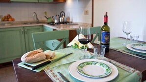Una tavola apparecchiata con piatti, bicchieri, una bottiglia di vino e una pagnotta.