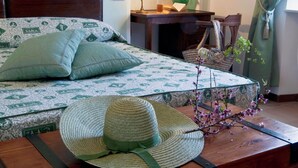 Una camera da letto ordinata con un letto, un comodino, una lampada e una sedia.
