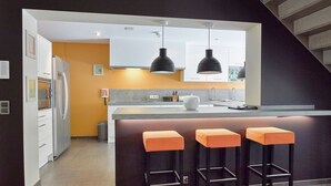 A modern kitchen with a central island, bar stools, and pendant lighting. - Spa Apartment With Private Pool (Spa)