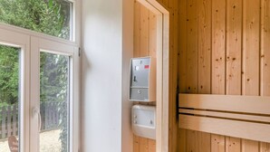 Ein Zimmer mit Holzwandverkleidung, einem Fenster mit weißem Rahmen und einer an der Wand befestigten Steckdose.
