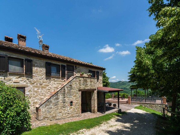 A stone building with a covered patio and a view of the countryside. - Gubbio Stay- the Countryside (Gubbio)