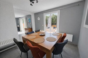 Un comedor con una mesa de madera, individuales tejidos y sillas modernas.