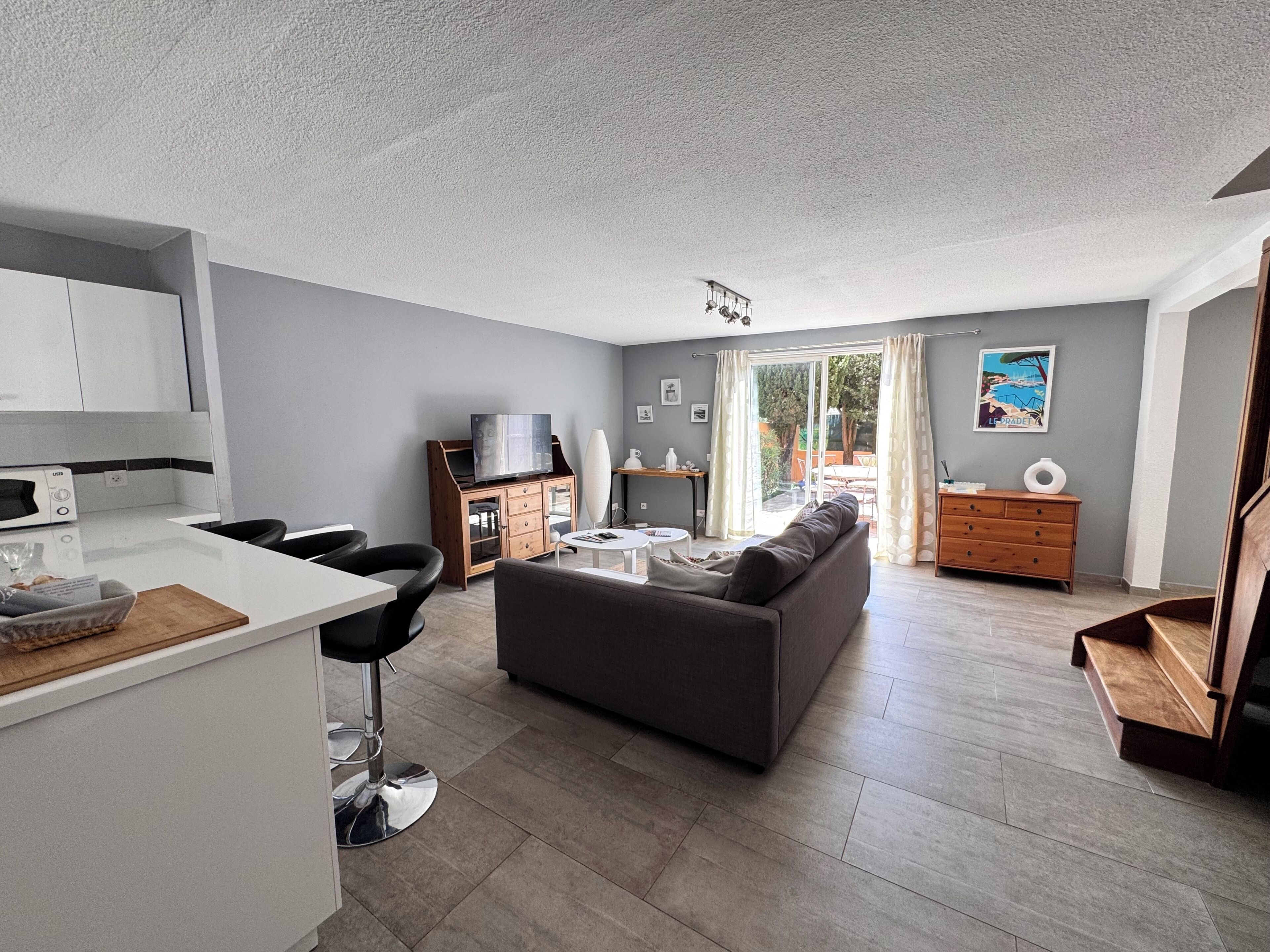 A modern apartment with a kitchen, dining area, and living room.