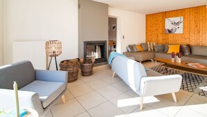 A modern living room with a fireplace, two sofas, a coffee table, and a floor lamp. - Luxurious Villa With Pool and Sauna, and Very Suitable for Culinary Workshops (Waimes)
