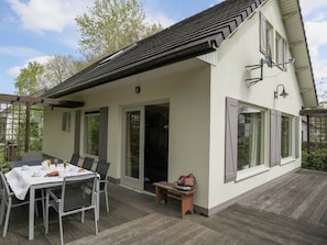 A house with a covered patio, a dining table with chairs, and a bench. - Rendeux Villa With Garden (Rendeux)
