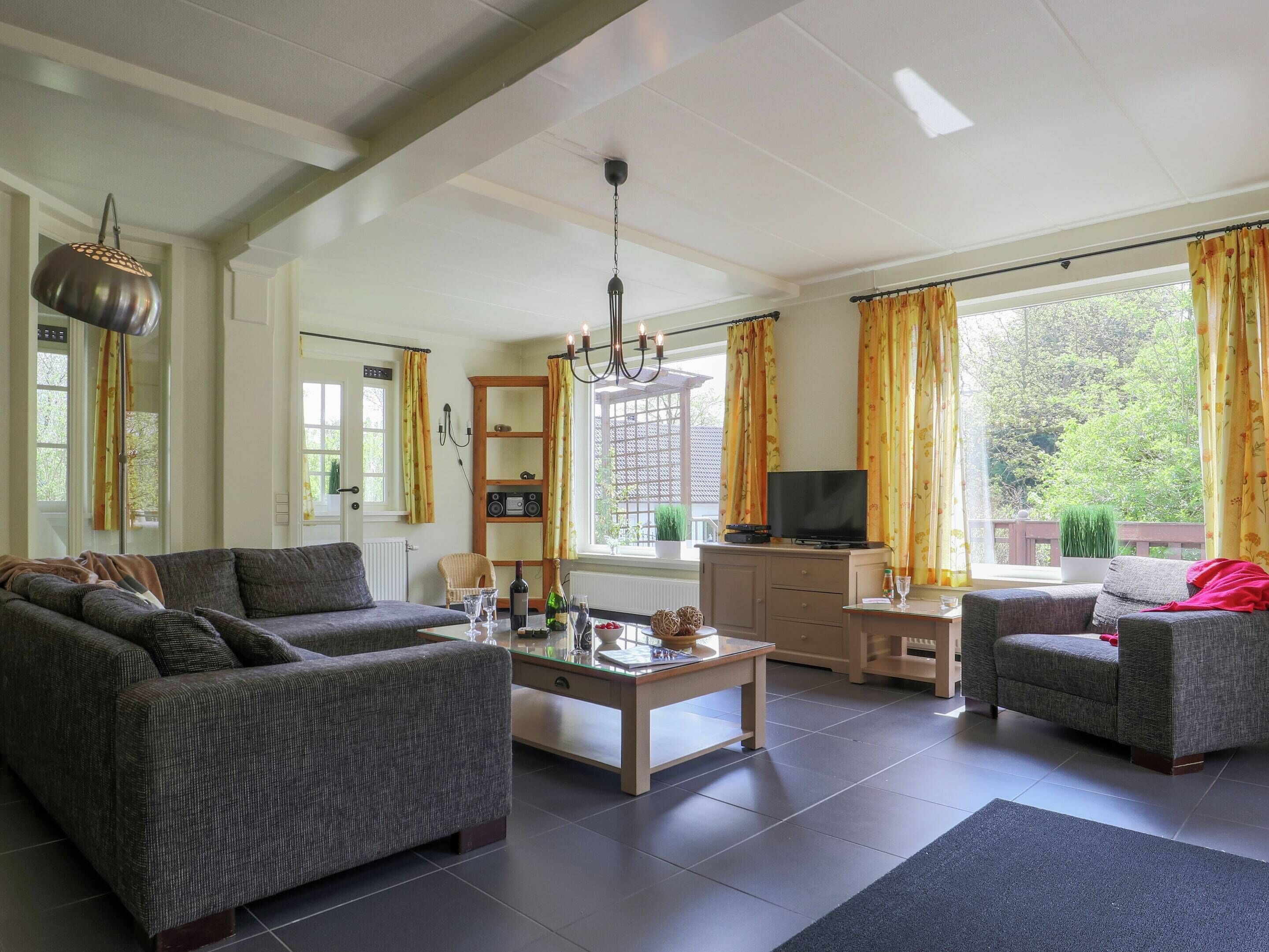 A living room with a sofa, a coffee table, a TV, and a bookshelf.