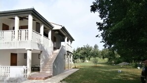 Ein zweistöckiges Haus mit Veranda, Treppe und Rasen.