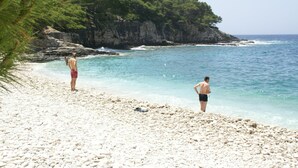 A beach with rocky terrain and a cliff in the background. - Coastal Apartment in Vis Near sea (Vis)