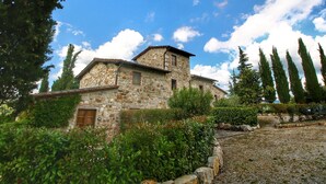 A stone building with a sloped roof, surrounded by greenery and trees. - Escape to Vineyards, Elba (Radda in Chianti)