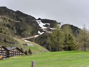 Et bjerg hotel med en skibakke, en træterrasse og en bygning med et skilt.