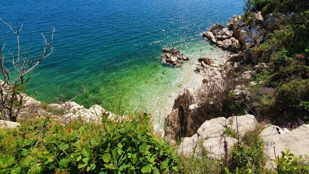 A coastal landscape with clear blue waters, rocky shores, and lush greenery. - Country House in Croatia With Pool (Crikvenica)