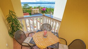 A balcony with a table and chairs, overlooking a scenic view of a lake and mountains. - Farm Stay in Croatia With Pool & Forest Views (Crikvenica)