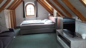 A bedroom with a bed, a TV, and a window. - Idyllically located in the center of Coswig (Coswig)