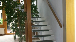 A staircase with wooden handrails and a potted plant at the bottom. - Idyllically located in the center of Coswig (Coswig)